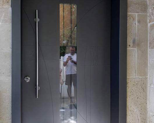 דלת כניסה מעוצבת בטכניקה יחודית המשלבת חלון סורג לייזר